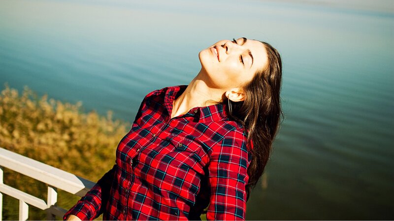 Woman in plaid shirt by the water
