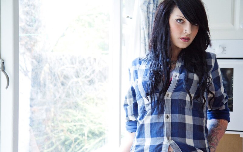 woman in plaid shirt by window