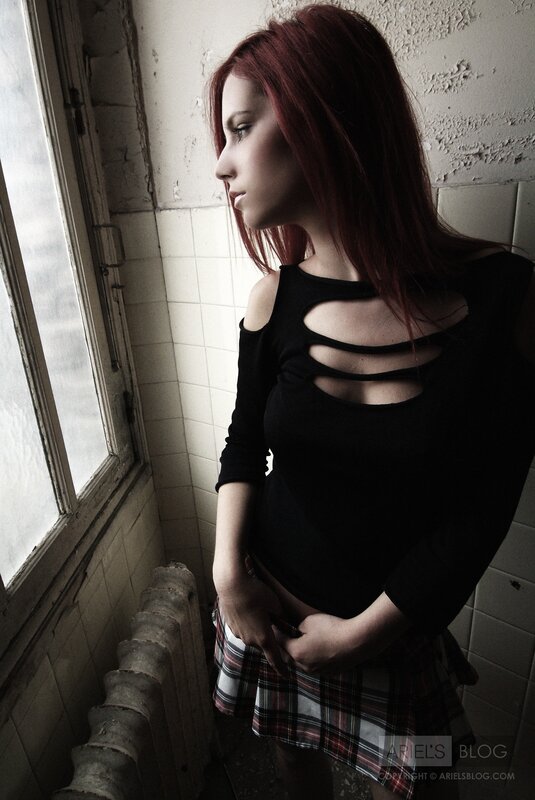 woman in plaid skirt by window