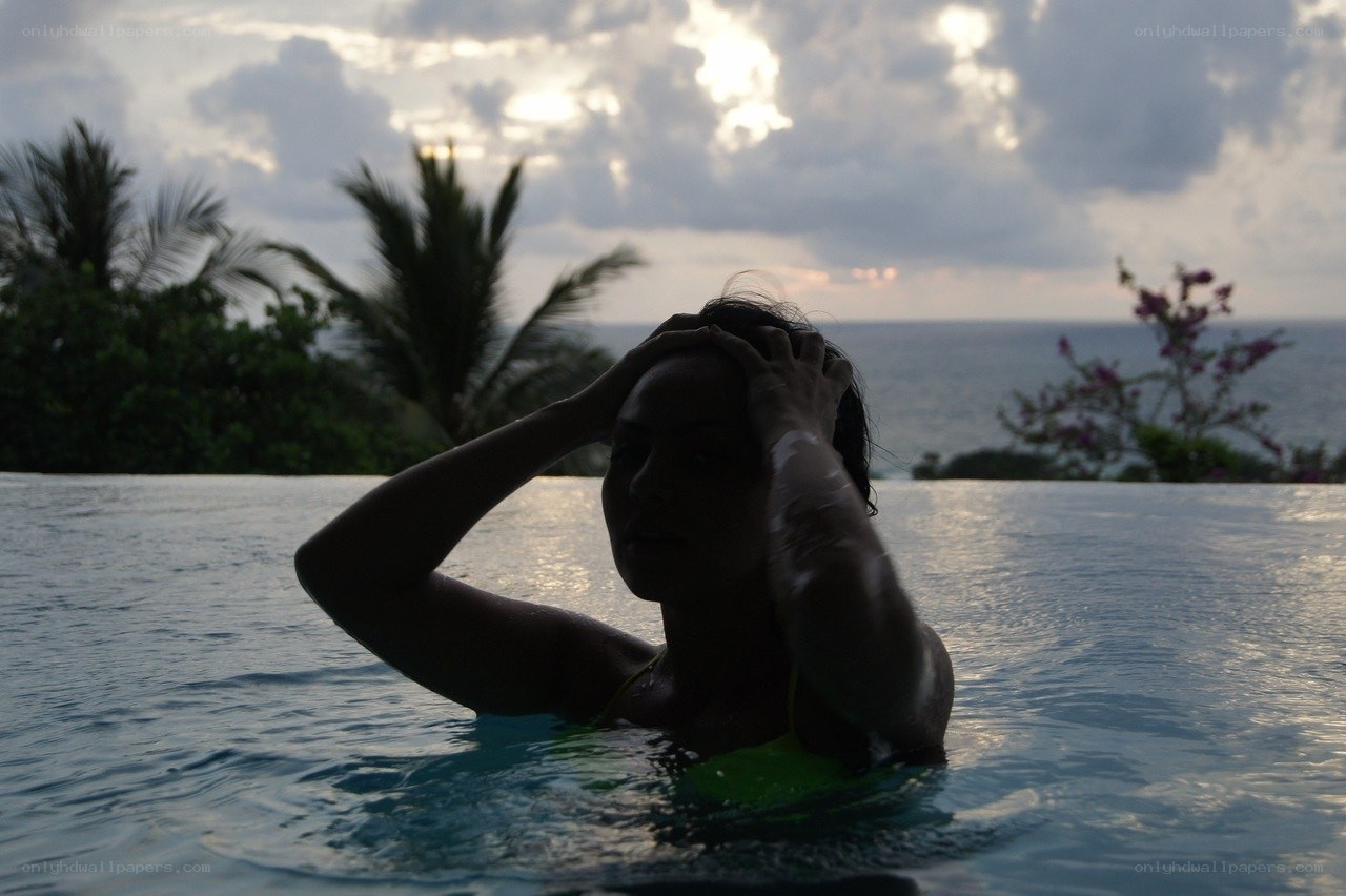 woman in pool at sunset