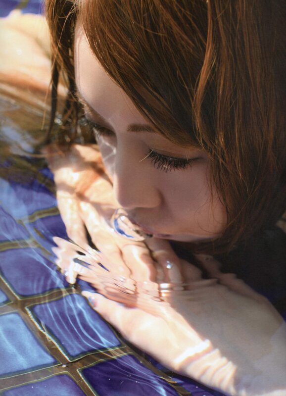 woman in pool with hands on tiles