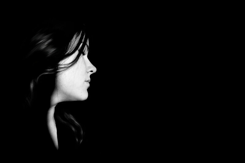 woman in profile against black