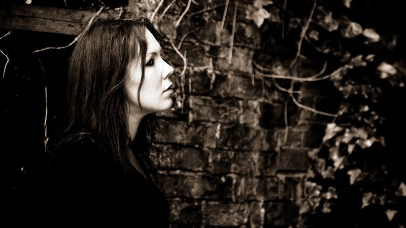 woman in profile against brick wall