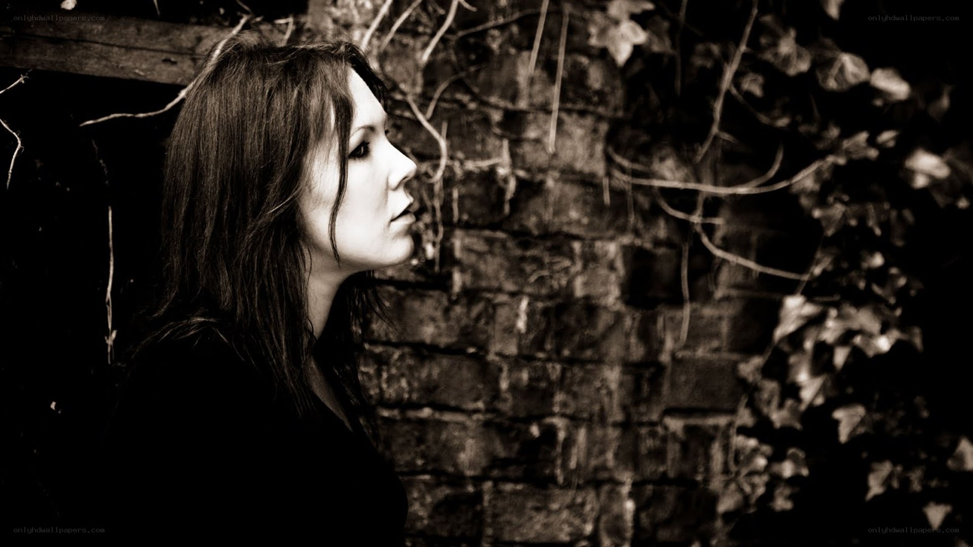 woman in profile against brick wall