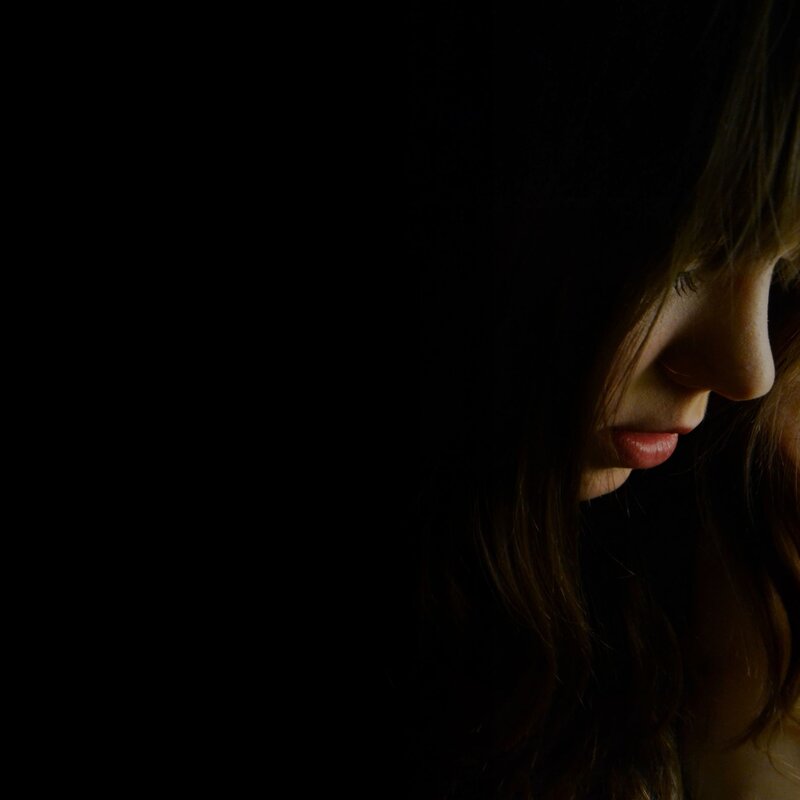 woman in profile against dark background