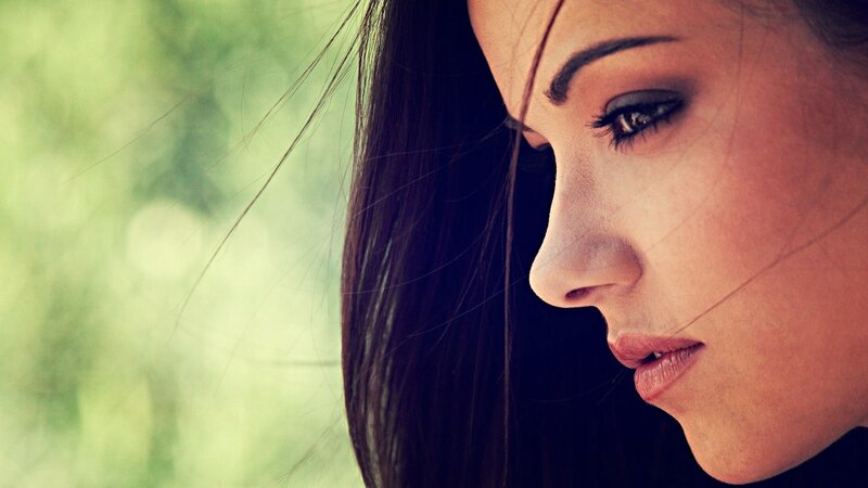 woman in profile with green background