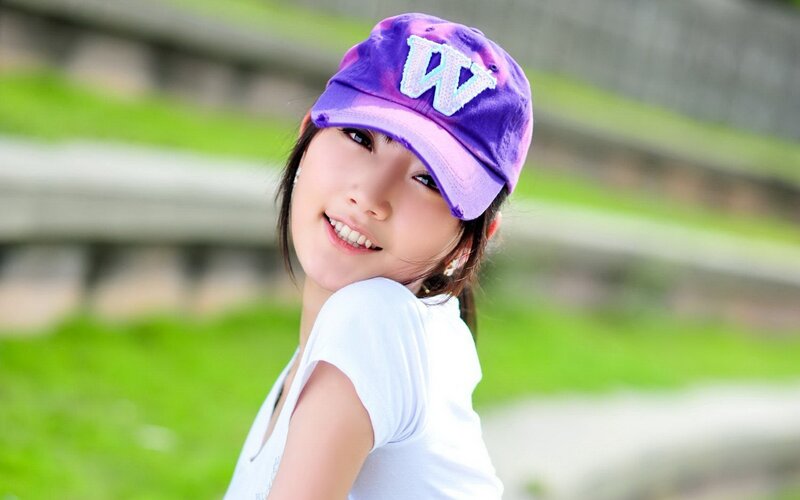 woman in purple cap smiling