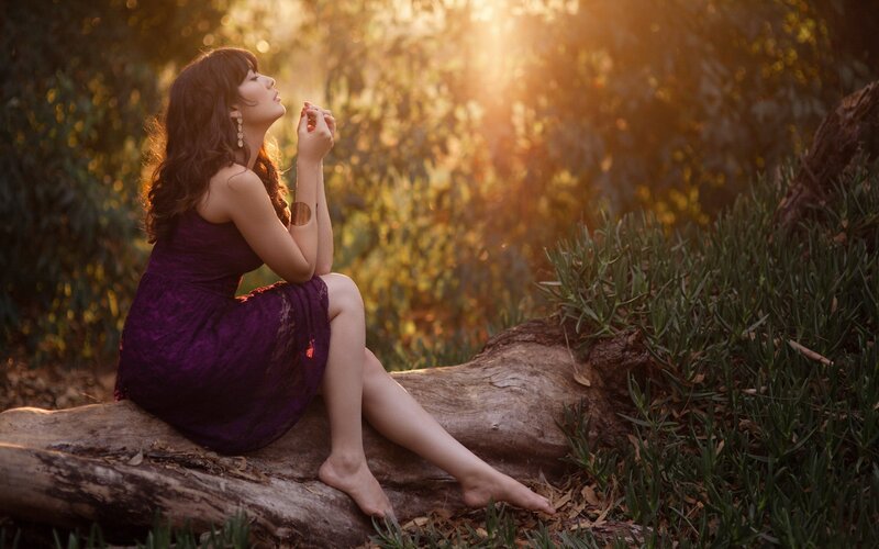 Woman in purple dress at sunset