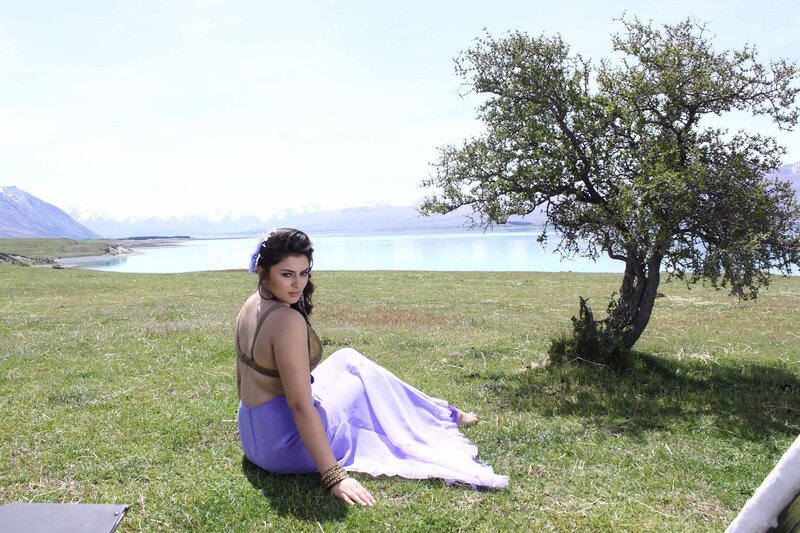 Woman in purple dress by lake