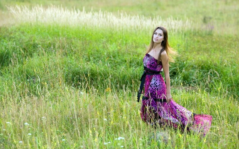 Woman in purple dress in field