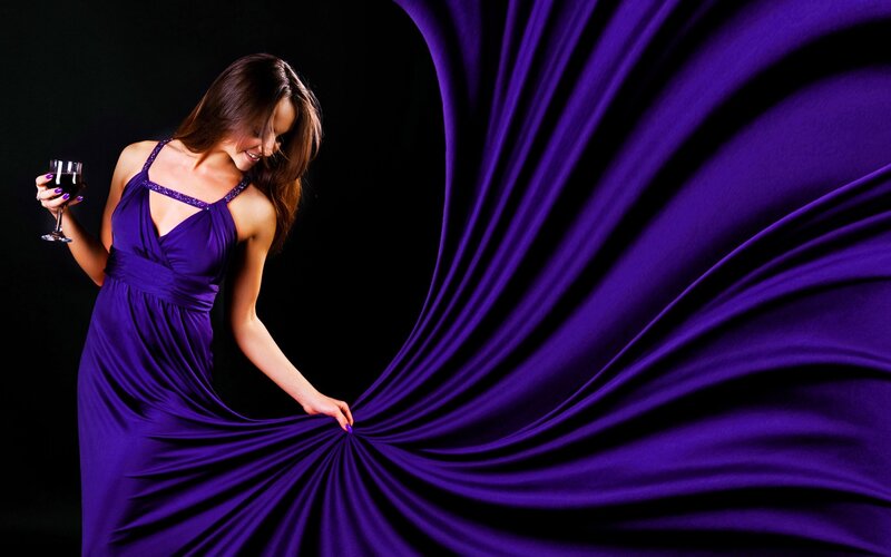 Woman in purple dress with wine