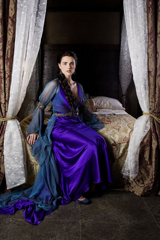 Woman in purple gown on bed