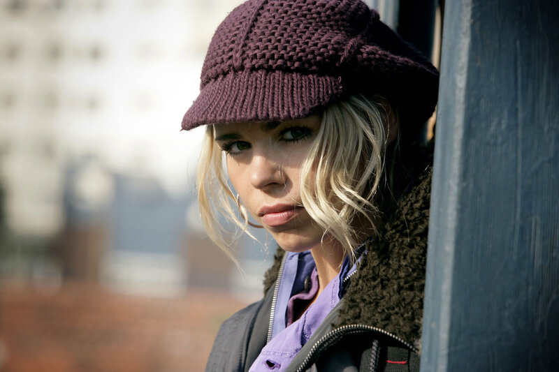woman in purple hat looking at camera