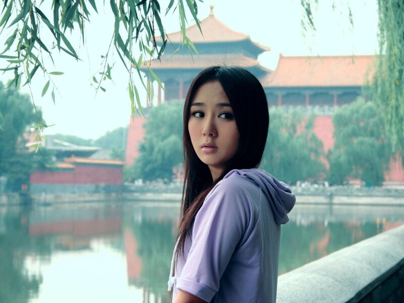 woman in purple hoodie by lake