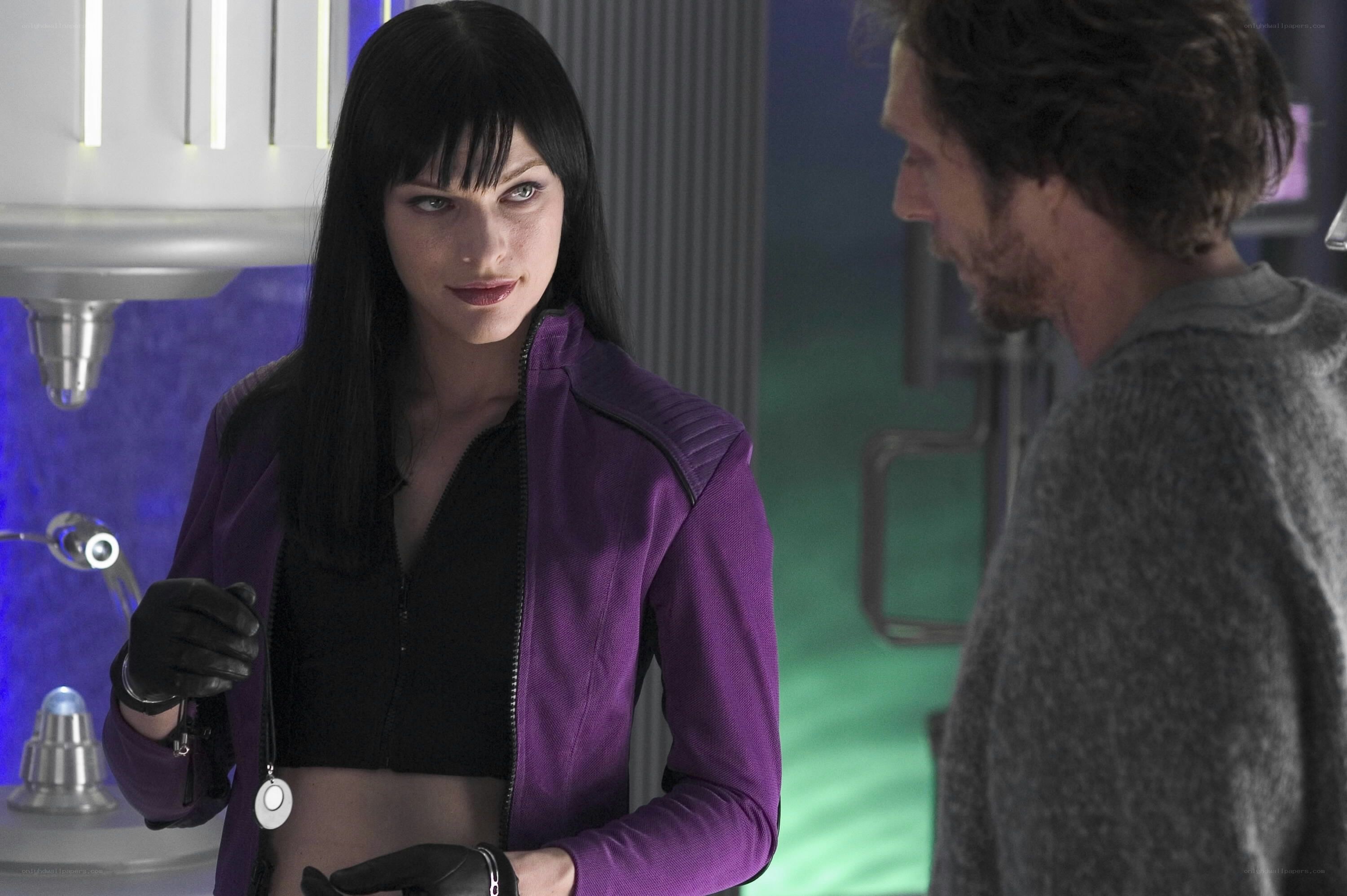Woman in purple jacket holding device