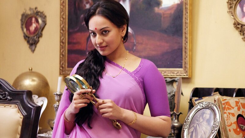 woman in purple sari holding magnifying glass