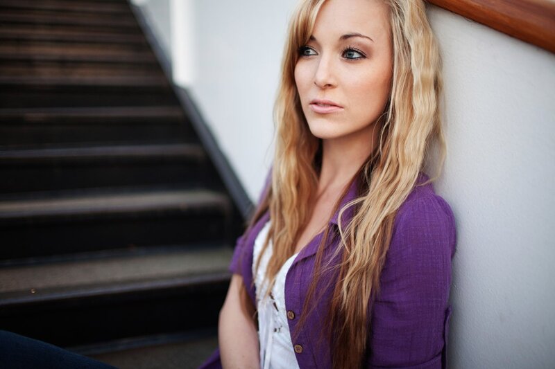 woman in purple shirt sitting on stairs