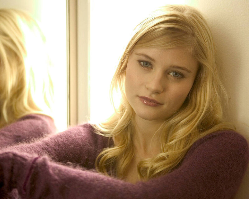 woman in purple sweater by window