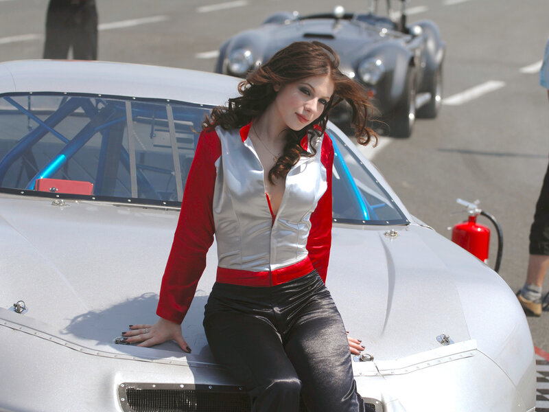 Woman in racing suit on car