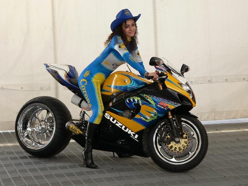 Woman in racing suit with motorcycle