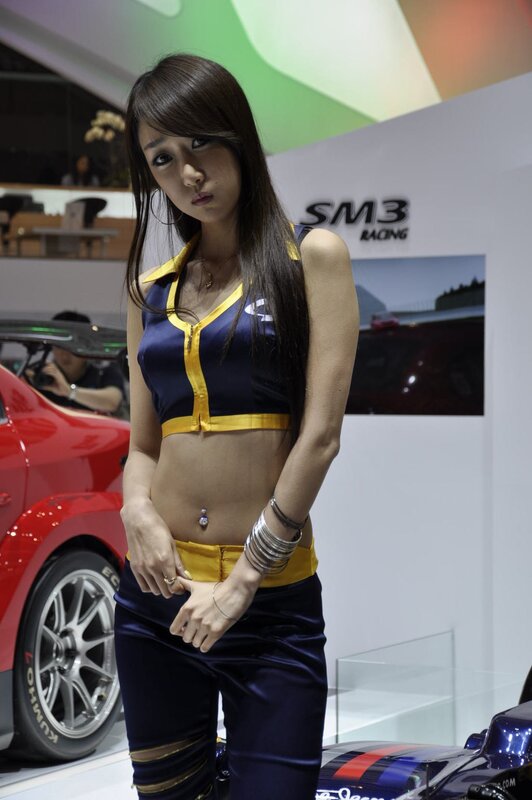 Woman in racing uniform at auto show