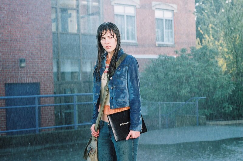 woman in rain holding book