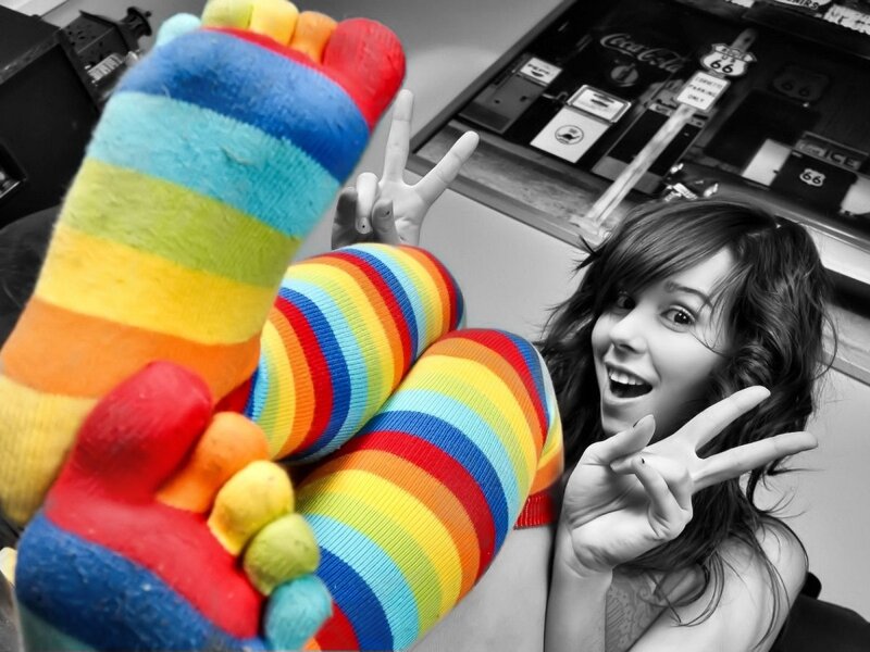 woman in rainbow socks making peace signs