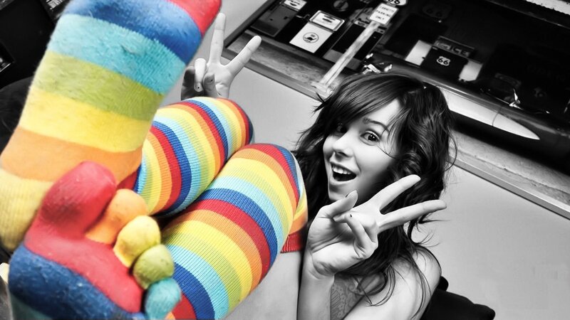 woman in rainbow socks making peace signs
