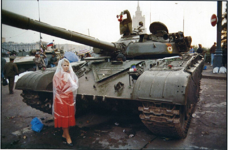 Woman in raincoat beside tank