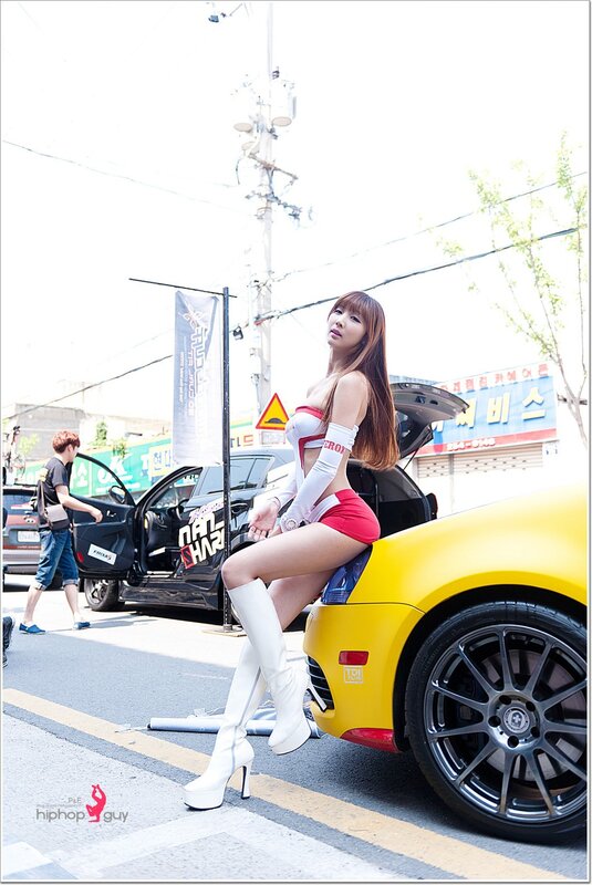 Woman in red and white outfit on yellow car