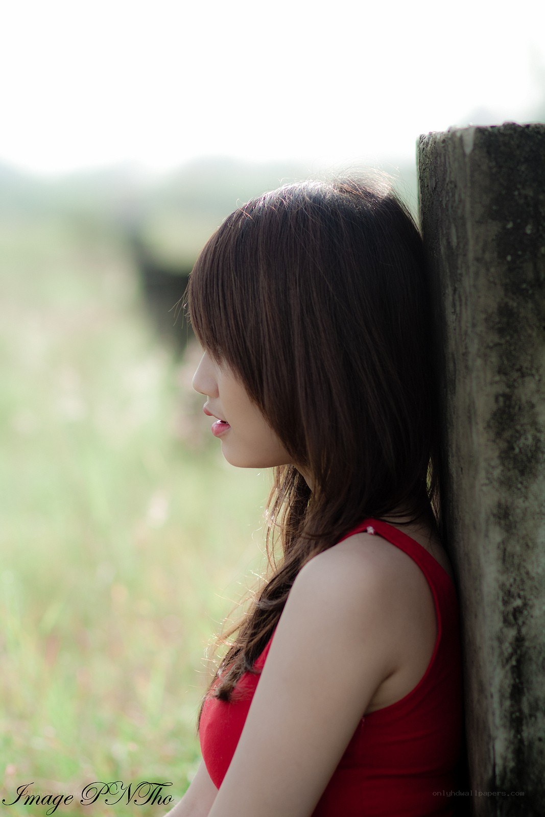 woman in red by a post