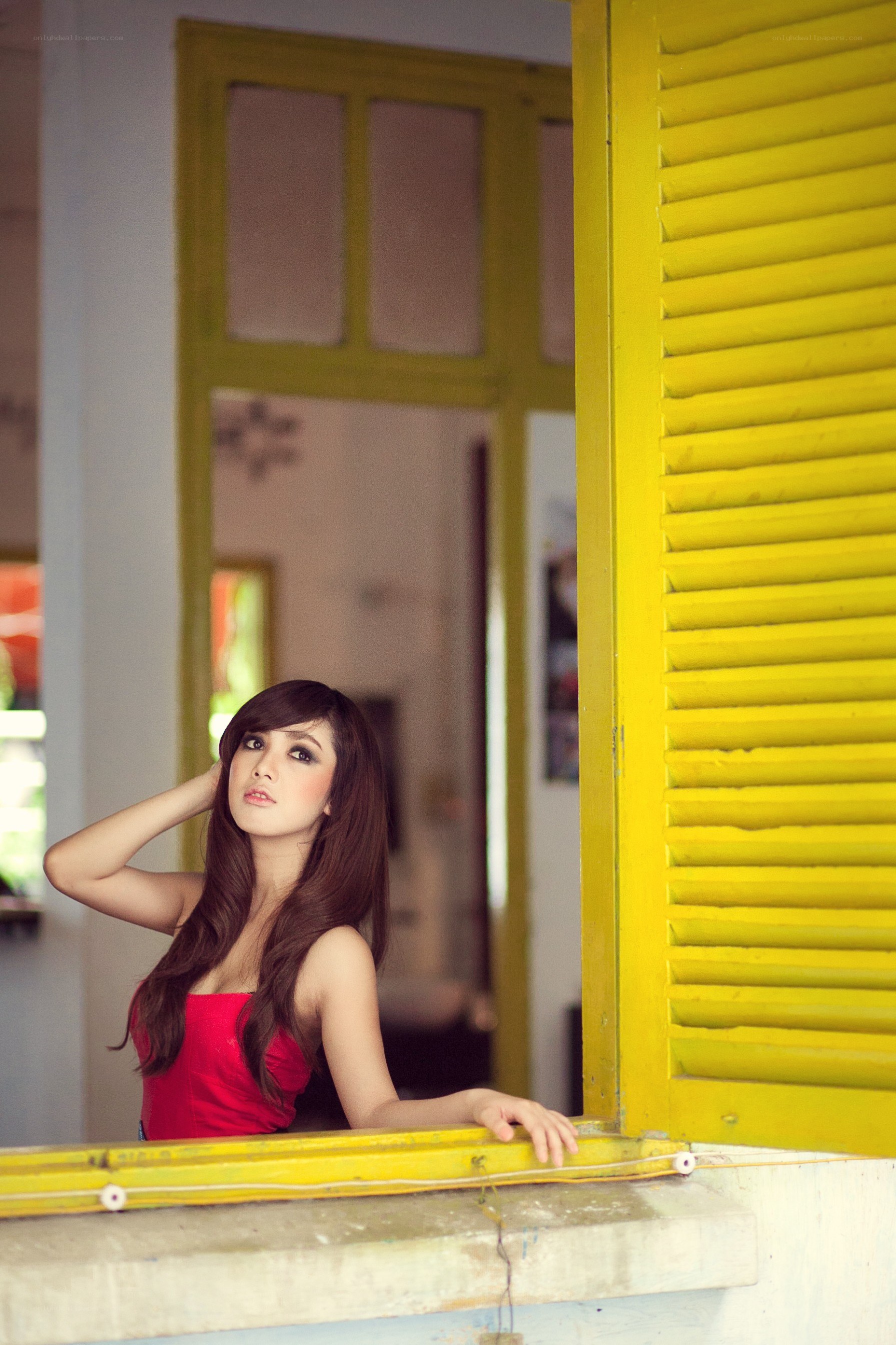 woman in red by yellow window