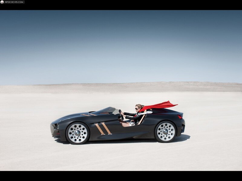 Woman in red cape driving concept car