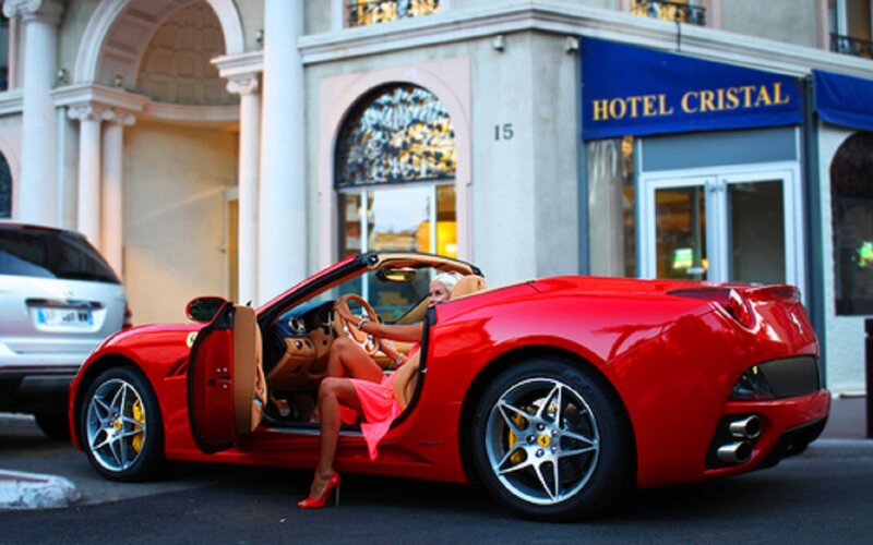 Woman in red car outside hotel