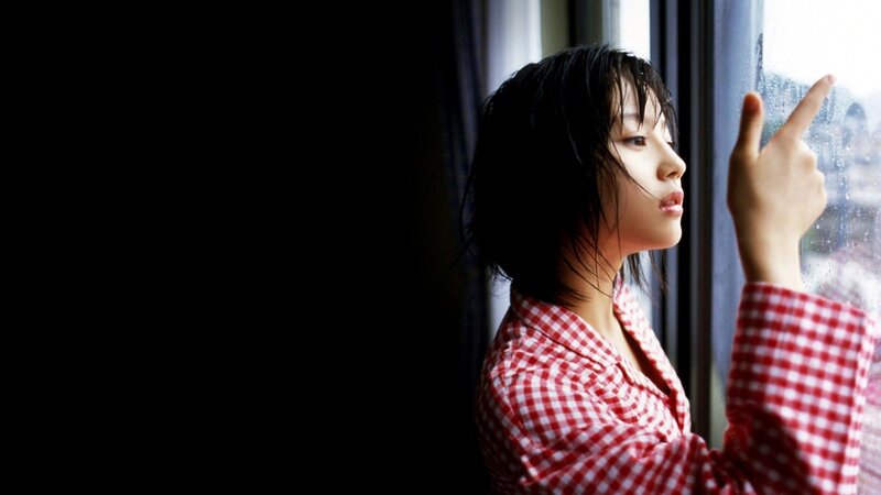 woman in red checkered shirt by window
