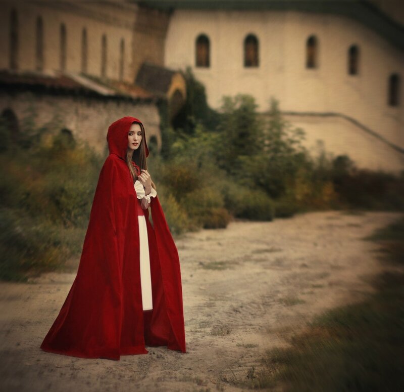 Woman in Red Cloak — Dramatic, Photograph, Building