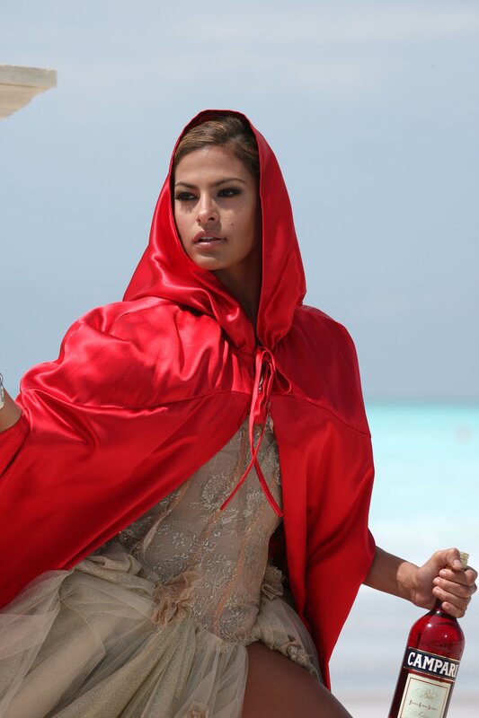 Woman in red cloak holding bottle