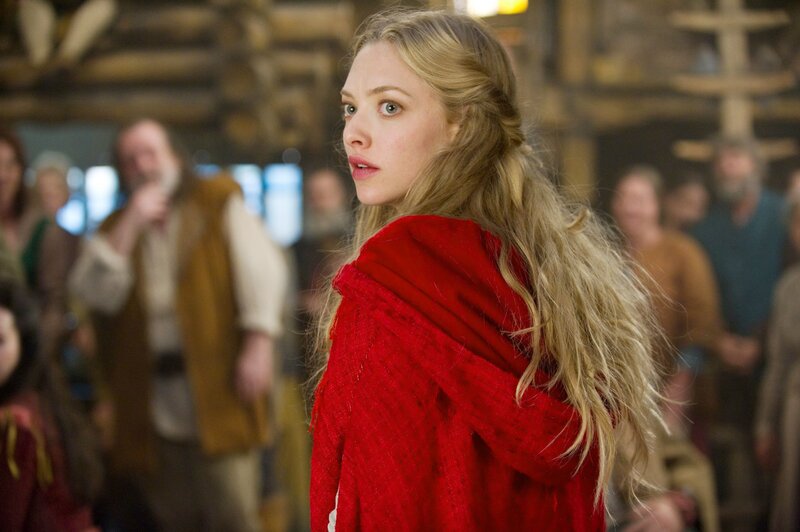 Woman in red cloak looks back