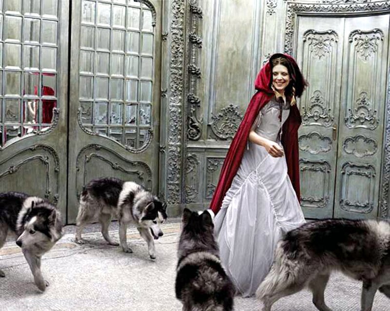 Woman in Red Cloak with Huskies