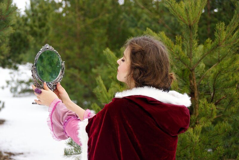 woman in red cloak with mirror