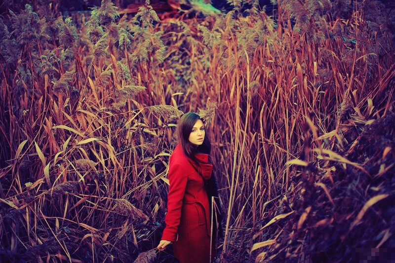 woman in red coat among reeds