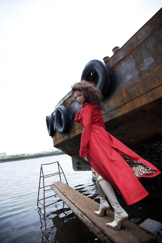 Woman in red coat by boat