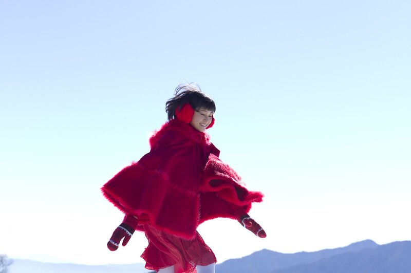 Woman in red coat dancing outdoors