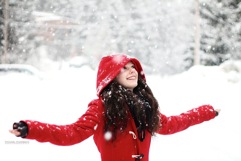 woman in red coat enjoying snow