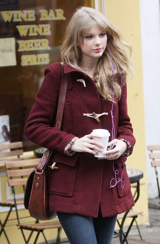 woman in red coat holding coffee
