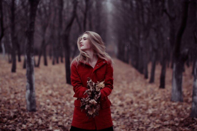 Woman in red coat holding leaves