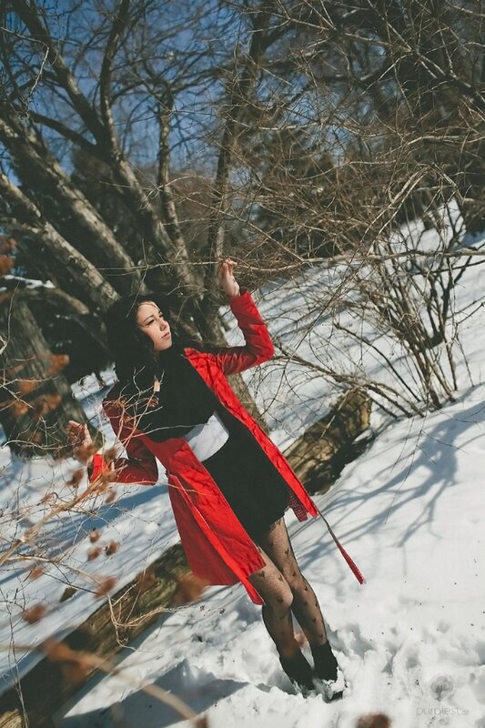 Woman in red coat in snowy woods