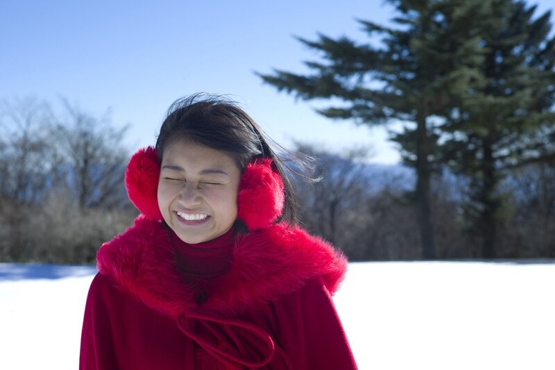 Woman in red coat laughing outdoors