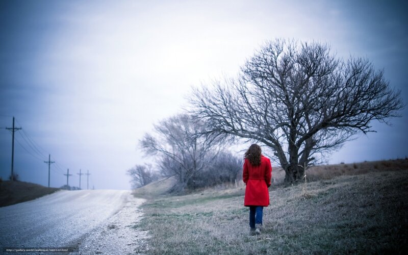 Woman in red coat on a road