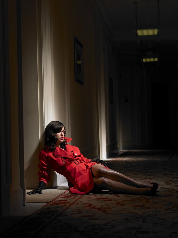 woman in red coat sitting on floor